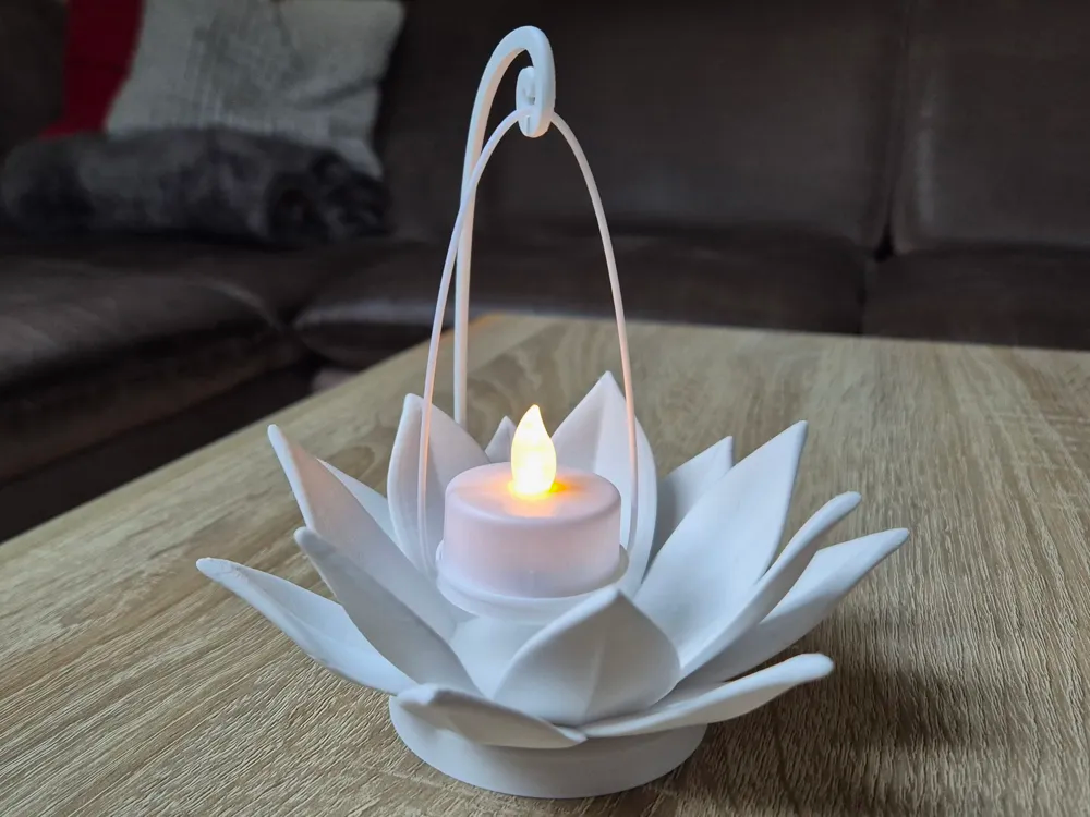 3D gedruckter weißer Lotusblüten-Teelichthalter als Dekoration auf einem Tisch.