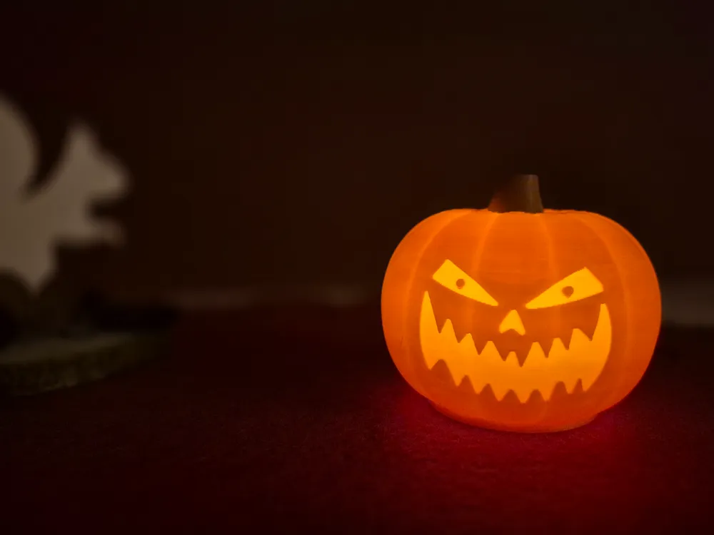 3D gedruckter Kürbis mit gruseligem Gesicht, leuchtend durch ein LED-Teelicht. 3D gedruckter Kürbis mit gruseligem Gesicht, leuchtend durch ein LED-Teelicht.
